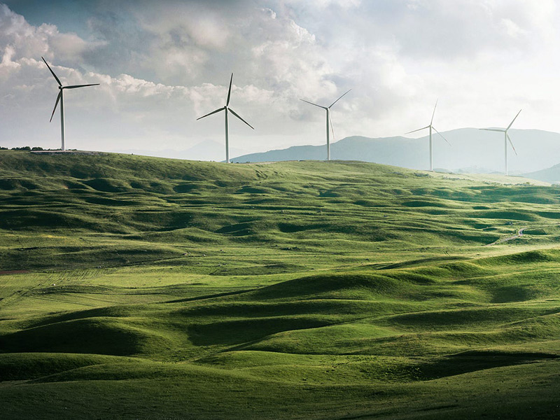 Image showing power windmills nestled in rolling green hills